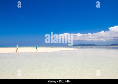 Ein paar auf einer Landzunge, weißen Sand von klaren, türkisfarbenen Wasser. Kondoi Strand, taketomi Insel (Taketomi-jima), yaeyama Inseln, in der Präfektur Okinawa, Japan. Stockfoto