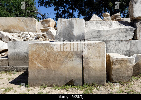 Griechische Inschriften unter den Ruinen der Bühne - Skene der Hellenistischen Theater, alte Stratonicea, Eskihisar, Türkei. Auf einem natürlichen Hang gebaut Stockfoto