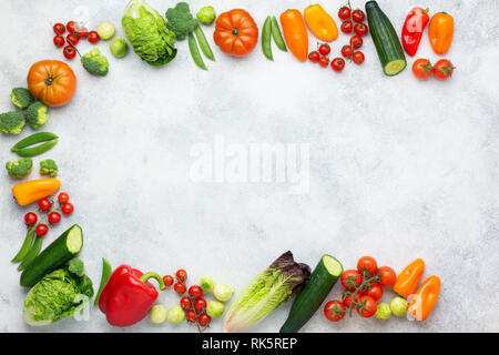 Raw Organic Farm produzieren, Tomaten Gurken salat Pfeffer avocado Frühlingszwiebel Brokkoli Erbsen auf dem weißen Beton Tabelle, Ansicht von oben, Kopieren, selektiven Fokus Stockfoto