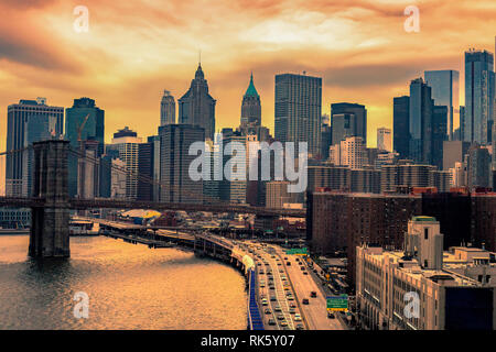 Ansicht des Manhattan Wolkenkratzer und der Brooklyn Bridge mit dem Verkehr im Sonnenuntergang Stockfoto