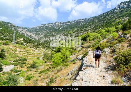 Afrikanische Frau, die den Wanderweg Vidova Gora auf der Insel Brac, Kroatien, hinaufgeht Stockfoto