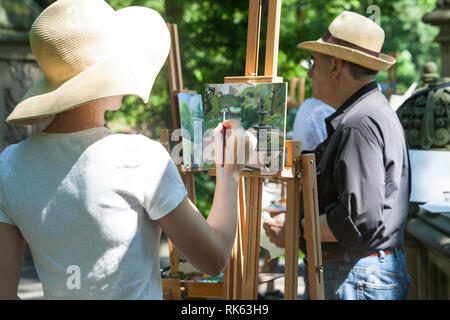 Ein Maler arbeitet auf einer Staffelei in der Malerei Klasse, Central Park, NYC Stockfoto