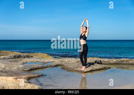 Sportlerin ein Aufwärmen dehnen am Meer Stockfoto