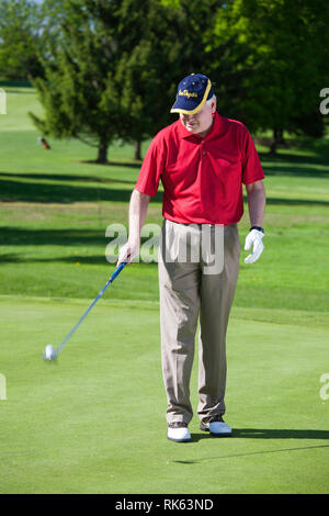 Reifen Golfspieler Bouncing Hi sBall auf seinen Putter, USA Stockfoto