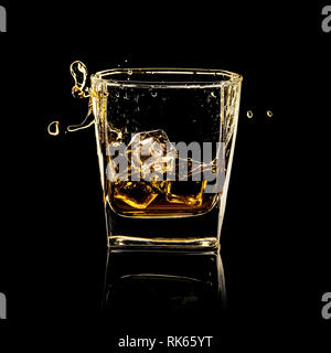 Glas spritzen Whisky mit Eis isoliert auf Schwarz Stockfoto
