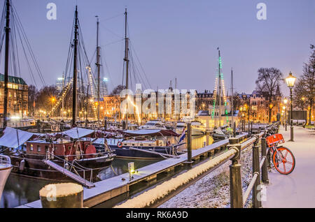 Rotterdam, Niederlande, 1. Februar 2019: Schnee bedeckt die historische Segelboote und die Kais am Veerhaven Marina in der blauen Stunde vor Sonnenaufgang Stockfoto