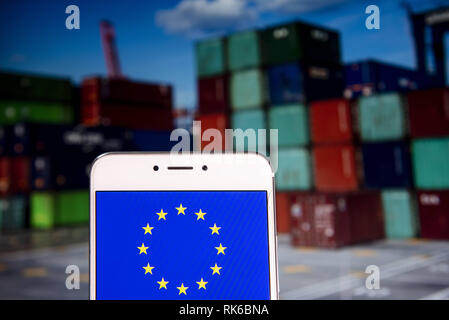 Hong Kong. 8 Feb, 2019. Fahne der Europäischen Union ist auf ein Android mobile Gerät mit einer Umladung Containerhafen im Hintergrund zu sehen. Credit: Miguel Candela/SOPA Images/ZUMA Draht/Alamy leben Nachrichten Stockfoto