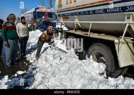 Kaschmir, Indien. 9. Feb 2019. Eine gestrandete Treiber Schneeräumen um seinen Lkw auf einer geschlossenen National Highway in Qazigund gesehen, ungefähr 85 km von Srinagar, Indien verwalteten Kaschmir. Die wichtigsten National Highway, die das Tal mit dem Rest des Landes verbindet blieb am Samstag im vierten aufeinander folgenden Tag geschlossen nach einer Lawine sieben Menschen, darunter auch die drei Polizisten töten, die zwei Feuerwehrmänner und die beiden Gefangenen. Credit: SOPA Images Limited/Alamy leben Nachrichten Stockfoto