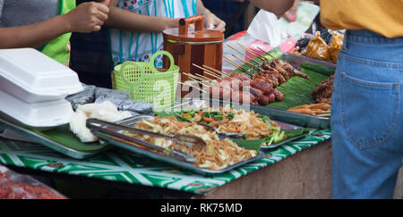 Traditionelle Thai Food Market Stall Verkauf von Sorten von Street Food, Fast und Komfort Lebensmittel wie Schweinefleisch oder Huhn Spieß, Pad Thai, Würstchen. Asiatische T Stockfoto