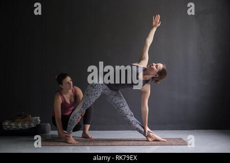 Yoga Instructor und Anfänger machen asana Übungen. Stockfoto