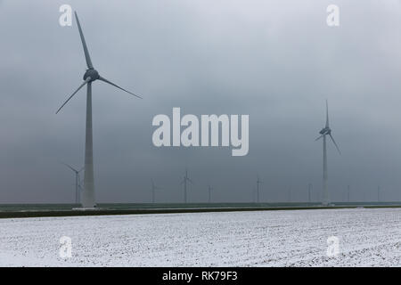 Holländische Landschaft mit Windkraftanlagen im Winter Haze Stockfoto