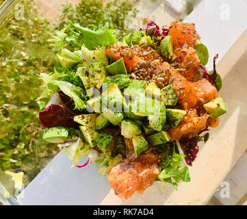 Gesunde leckere frische Mahlzeit mit grünem Salat, Avocado, Lachs vorbereitet, Samen Stockfoto