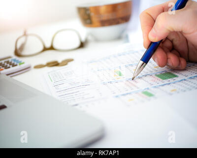 Nahaufnahme der Hand des Menschen schreiben, Zeitpläne und Finanzen mit Brille und Kaffeebecher im Hintergrund Stockfoto