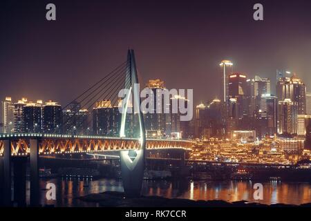 Qiansimen Brücke mit Hongyadong Shopping Complex und Stadt städtische Architektur bei Nacht in Chongqing, China. Stockfoto