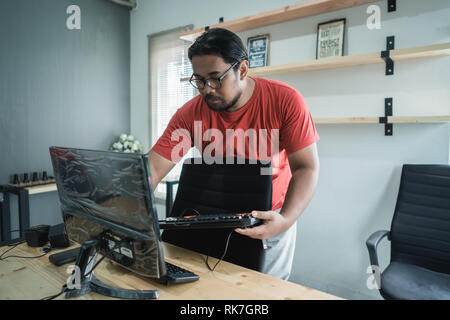 Portrait von Techniker fix einen Computer mit der Reparatur ein Problem der Tastatur im Büro Stockfoto