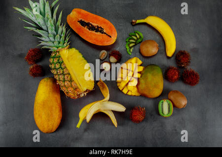 Tropische Früchte Sortiment auf einem dunklen Hintergrund mit der Ansicht von oben. Stockfoto