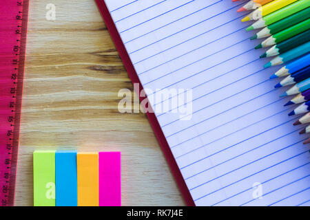 Schule und Zeichnung liefert, auf hölzernen Tisch. Übungen Buch, Buntstifte, Haftnotiz und Lineal. Mit kopieren. Stockfoto