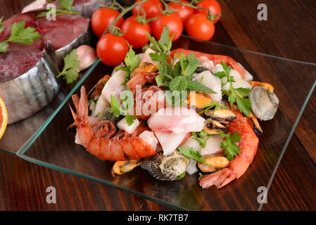 Glas Gerichte mit Fisch bonito Muscheln und Schalentieren raw auf der Holzplatte