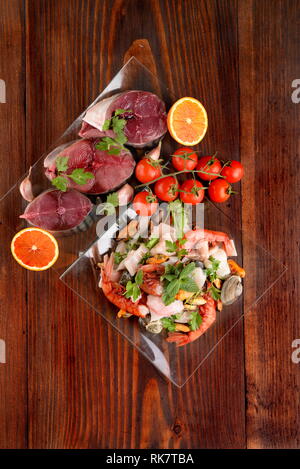 Glas Gerichte mit Fisch bonito Muscheln und Schalentieren raw auf der Holzplatte