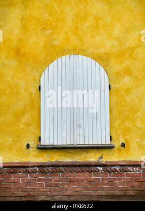 Hälfte - zeigen Fenster auf einem Sienna Farbe Wand. Asti, Piemont, Italien. Stockfoto