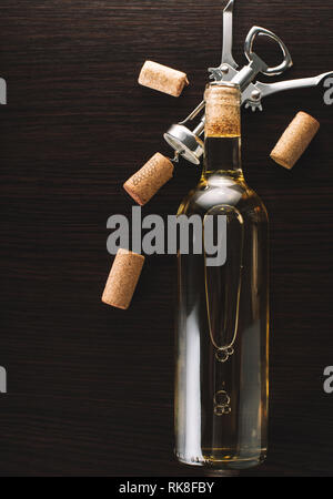 Flasche Wein und Korkenzieher auf hölzernen Hintergrund Stockfoto