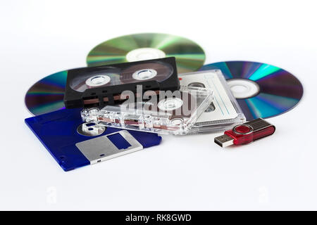 Verschiedene Medien - USB-Flash-Laufwerk, CD-ROM, CD-Kassette, die Disketten auf einem weißen Hintergrund Stockfoto