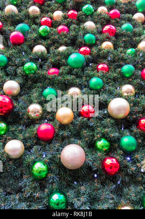 Rot und grün farbigen Kugeln auf einen künstlichen Weihnachtsbaum. Stockfoto