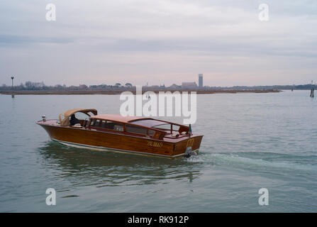 Venedig, Italien - 3. Januar 2014: Ein wassertaxi Überquerung der Lagune von Venedig auf eine romantisch-düstere Tag. Stockfoto