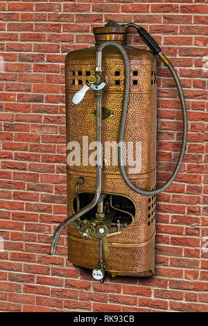 Vintage Gas Wasser Heizung mit Dusche auf der Backsteinmauer. Retro Durchlauferhitzer mit Tippen. Stockfoto