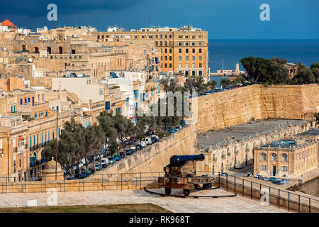 Blick auf alte Kanone auf Bastion als Stadt Valletta auf Hintergrund. Stockfoto