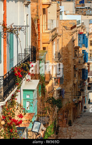 Vertikal orientierten Bild der typischen Gebäude aus Stein mit bunten Balkonen entlang der schmalen Straße in Valletta, Malta. Stockfoto