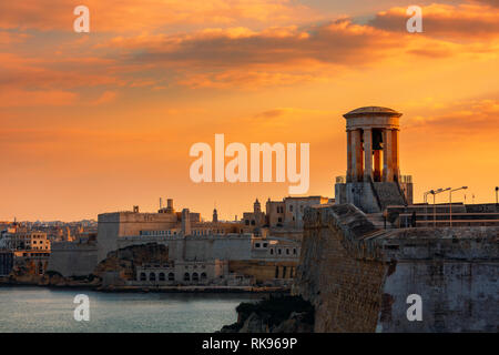 Ansicht der Belagerung Bell War Memorial in alten Mauern und Festung auf Hintergrund unter schönen Abendhimmel in Valletta, Malta. Stockfoto