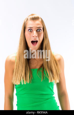 Neugierige junge Frau in grün Tanktop Stockfoto