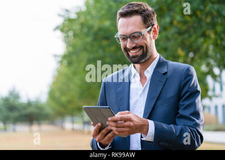 Lächelnde Geschäftsmann mit digital-Tablette Stockfoto