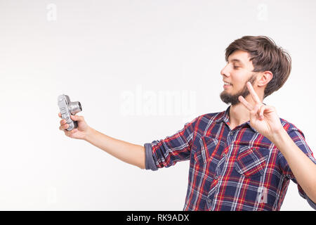 Menschen, Fotograf und Geste Konzept - Mann mit einem altmodischen Kamera schaut durch die Linse auf weißem Hintergrund Stockfoto