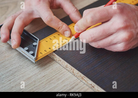 Tischler Hände unter Messung der Holzbrett, in der Nähe Stockfoto
