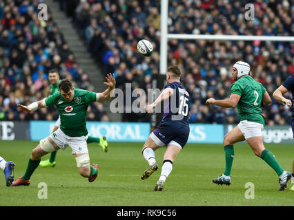 Schottland's Stuart Hogg Kicks vor kurz vor Ende der Herausforderung von Irlands Peter Peter O'Mahony (links) Während der Guinness sechs Nationen match bei BT Murrayfield, Edinburgh verletzt werden. Stockfoto