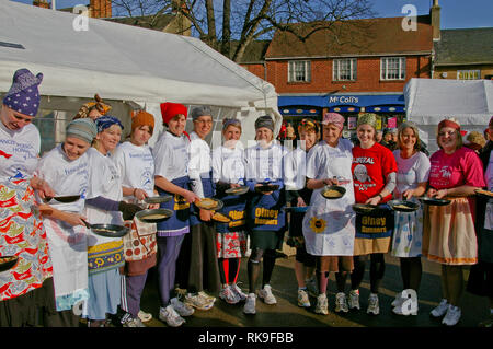 Lächelnde Damen oben Futter in den Marktplatz für den Beginn der berühmten olney Pancake Race, sagte, das älteste der Welt, Buckinghamshire, Großbritannien Stockfoto