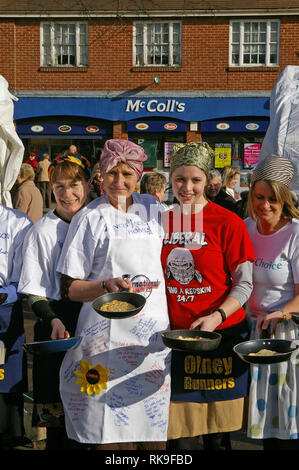 Lächelnde Damen oben Futter in den Marktplatz für den Beginn der berühmten olney Pancake Race, sagte, das älteste der Welt, Buckinghamshire, Großbritannien Stockfoto