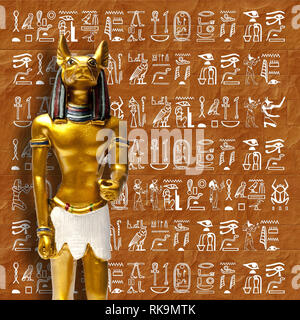 Ägyptischer Gott Anubis vor einem Hieroglyphen an der Wand Stockfoto