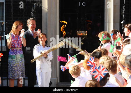 Die olympische Fackel erreicht Premierminister David Cameron mit seiner Frau Samantha Cameron bei Nummer 10 Downing Street von Ceri Davies, die an der Flamme zu Florenz Rowe, der fackellauf weitergegeben wird Morgen mit der Ankunft im Olympischen Park für die Eröffnungsfeier der Olympischen Spiele 2012 in London. 25. Juli 2012 --- Bild von: © Paul Cunningham Stockfoto