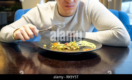 Mann ohne Gesicht Salat im Cafe sitzen. Stockfoto