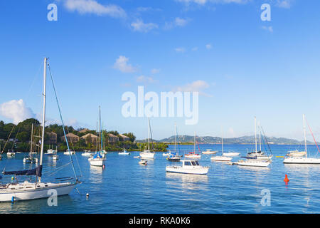 Yachten in der Nähe der Pier in St. John Island, USA VI. Angelegte Boote in Karibik mit ruhigem Wasser, mit fernen Inseln am Horizont. Stockfoto