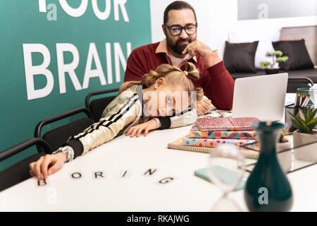 Adorable blonde Mädchen mit Armbänder auf ihre Hand müde Stockfoto