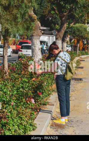 Istanbul, Türkei, 21. September 2018: Slim Kaukasischen weibliche Touristen mit Rucksack, das Tragen von Hosen, die Bilder von Blumen auf der Straße. Stockfoto