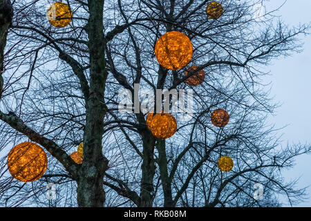 Runde Kugeln mit Lichtern in den Bäumen hängen, schöne im Winter Dekorationen Stockfoto