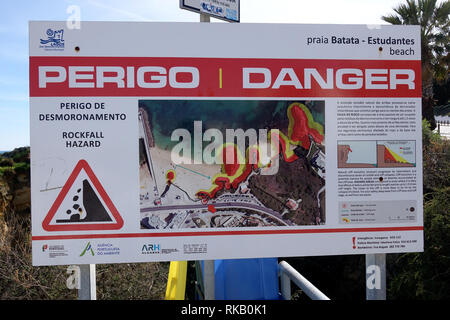 Warnschild Warnung Touristen über Steinschlag am Strand von Lagos Portugal Stockfoto