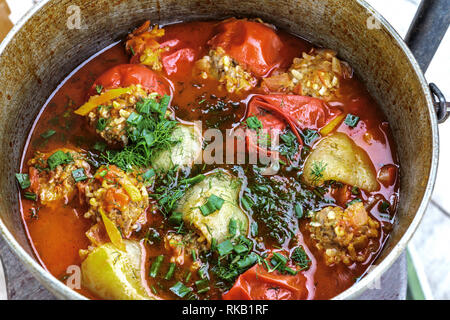 Gefüllte Paprika und Tomaten in einer Form gekocht - Bügeleisen Kessel mit Wasser. Gesunde hausgemachte Speisen. Lecker im Sommer essen. Stockfoto