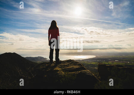 Silhouette eines Mädchens auf einer Klippe bewundern die schöne Landschaft, mitten in der Natur, in Katalonien, Spanien Stockfoto