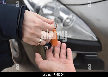 Auto Verkauf. Eine Person verkauft Auto und gibt den Schlüssel für den neuen Eigentümer - Bild Stockfoto